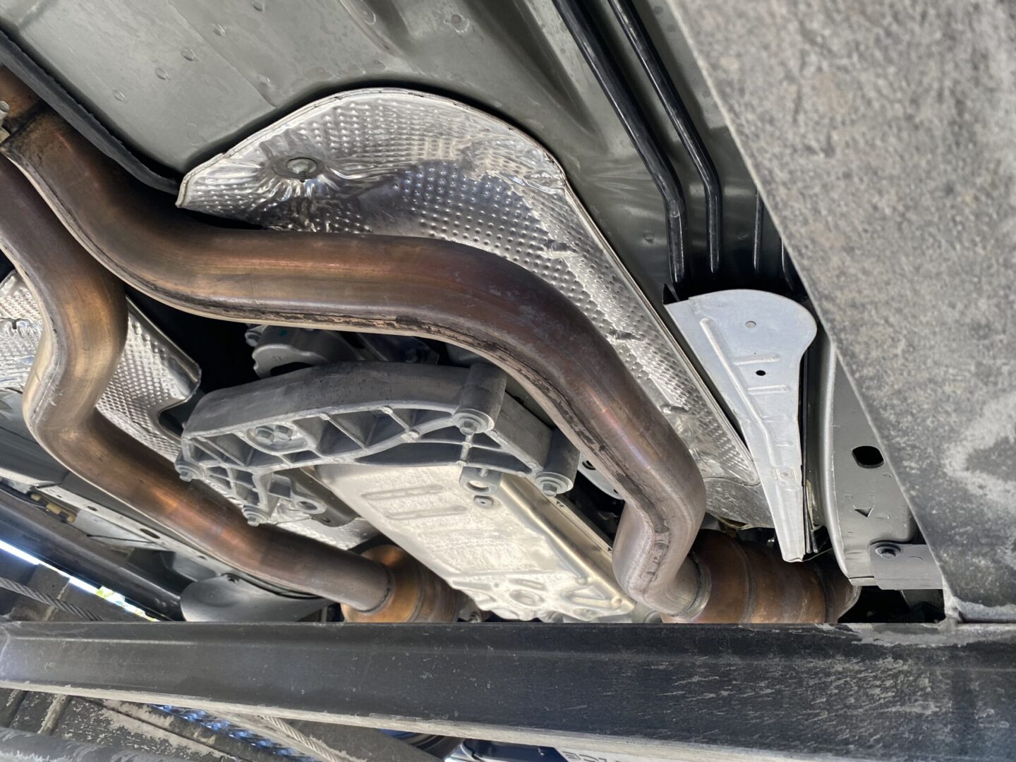Car undercarriage with exhaust pipes visible.