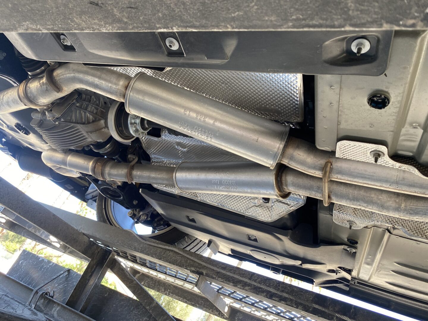 Car exhaust system under vehicle inspection.