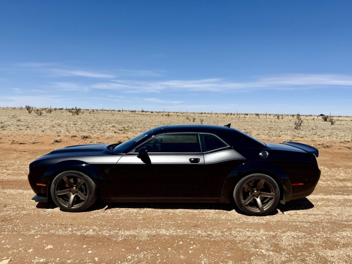Black sports car on a desert road.