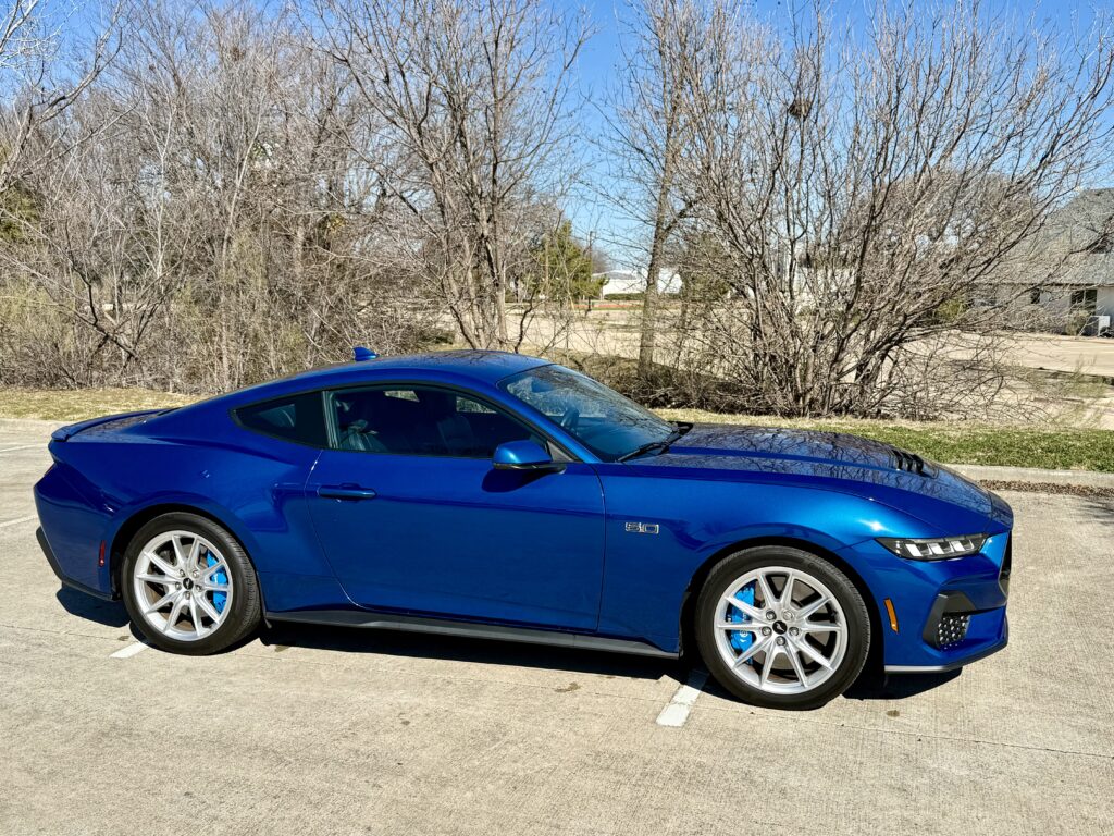 Blue sports car parked on sunny day.
