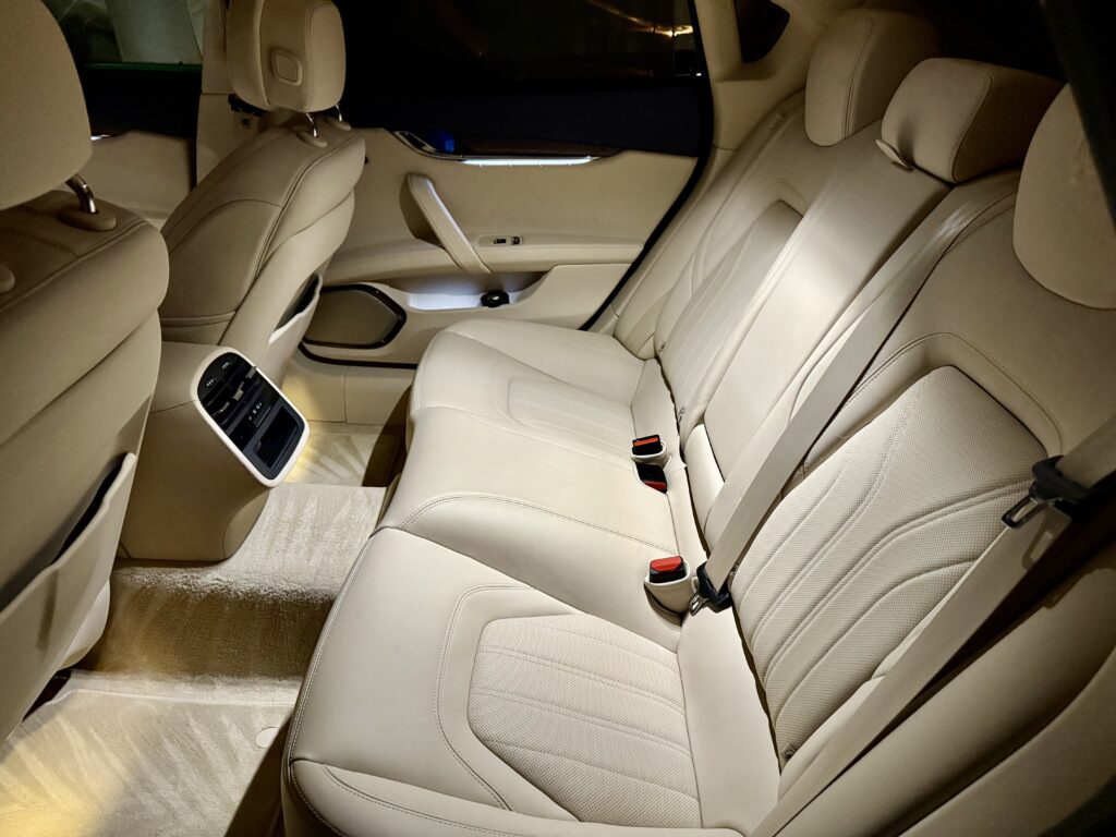 Luxury car interior with beige leather seats.