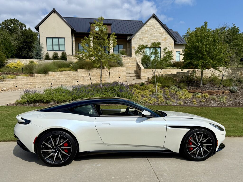 White sports car parked near modern house.